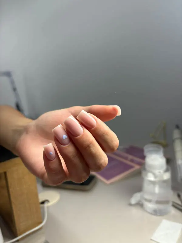 Nude hard gel manicure with delicate blue heart art by Elena